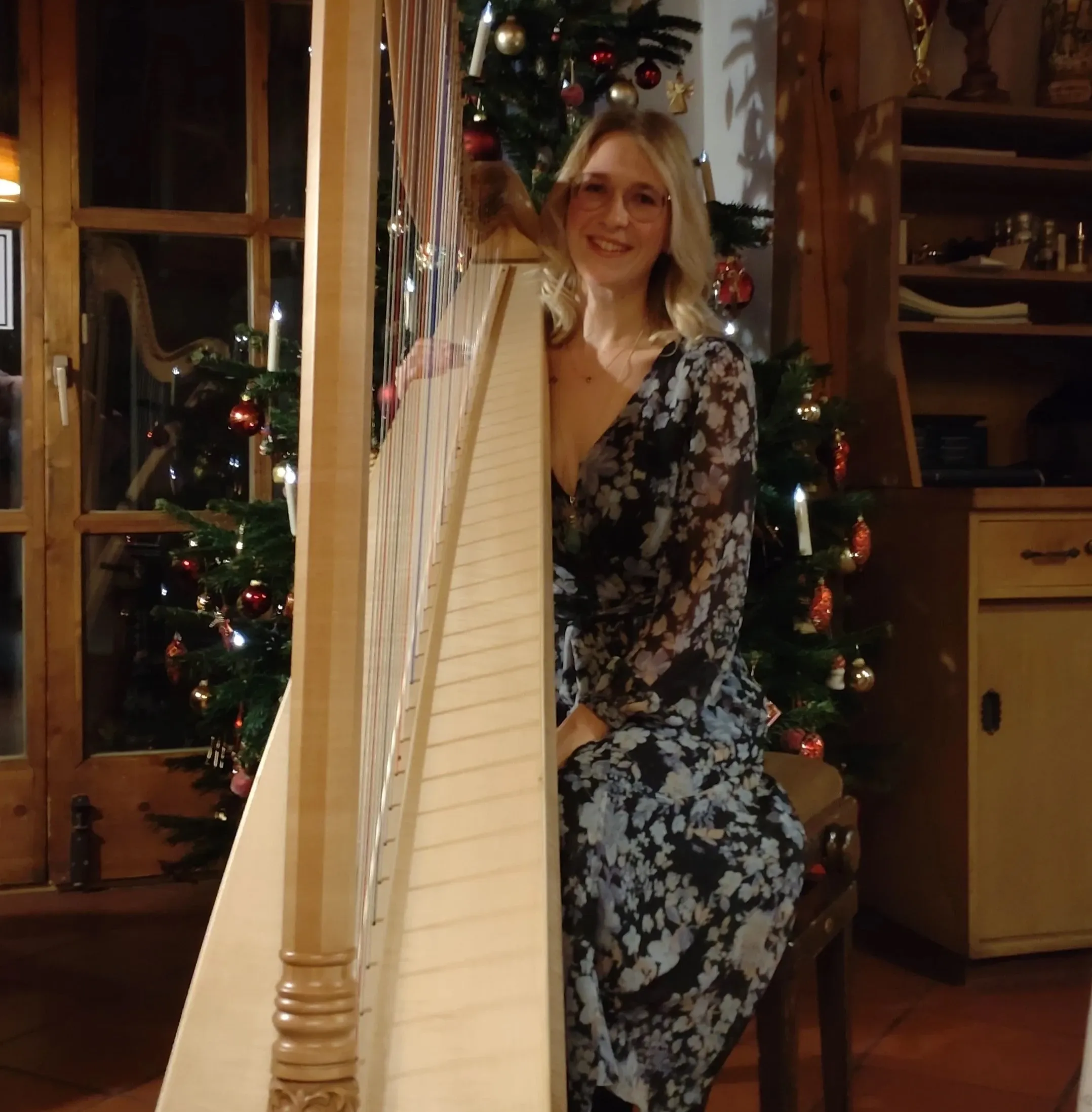 Katharina Wutz spielt zur Weihnachtszeit Harfe vor einem geschmückten Christbaum